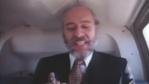 Old bearded man in a suit getting head in a helicopter